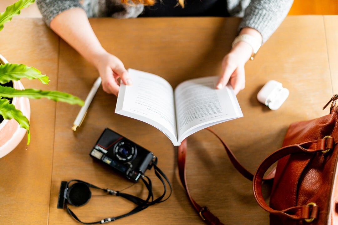 person reading book at desk