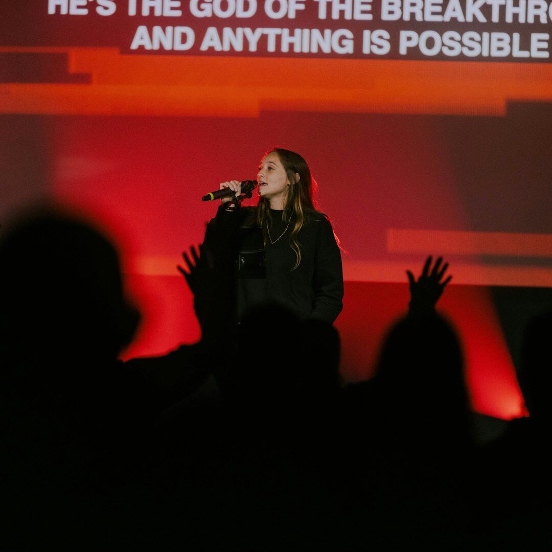 Brazilian woman speaking on stage with a microphone